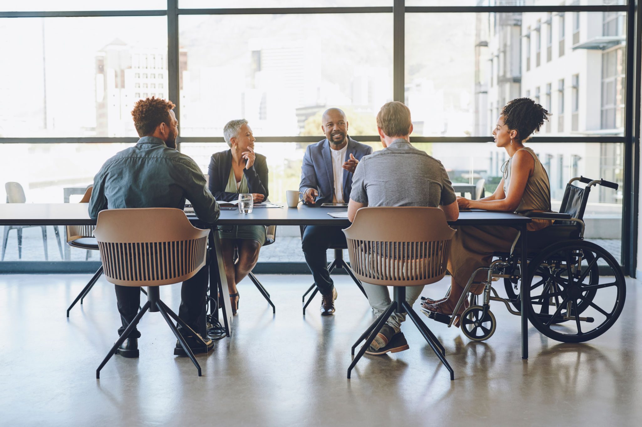 Meeting with diverse group around conference table.