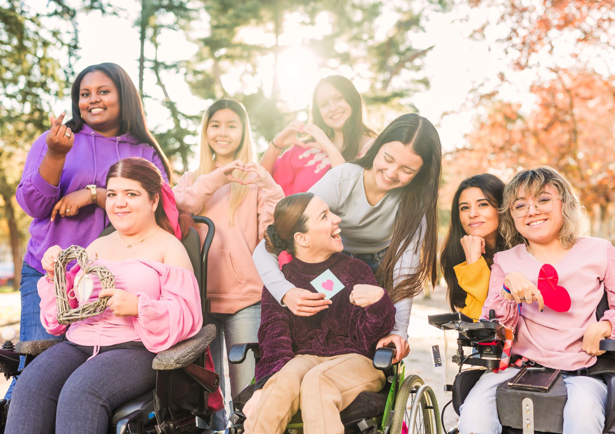 Diverse group of women smiling outdoors together.