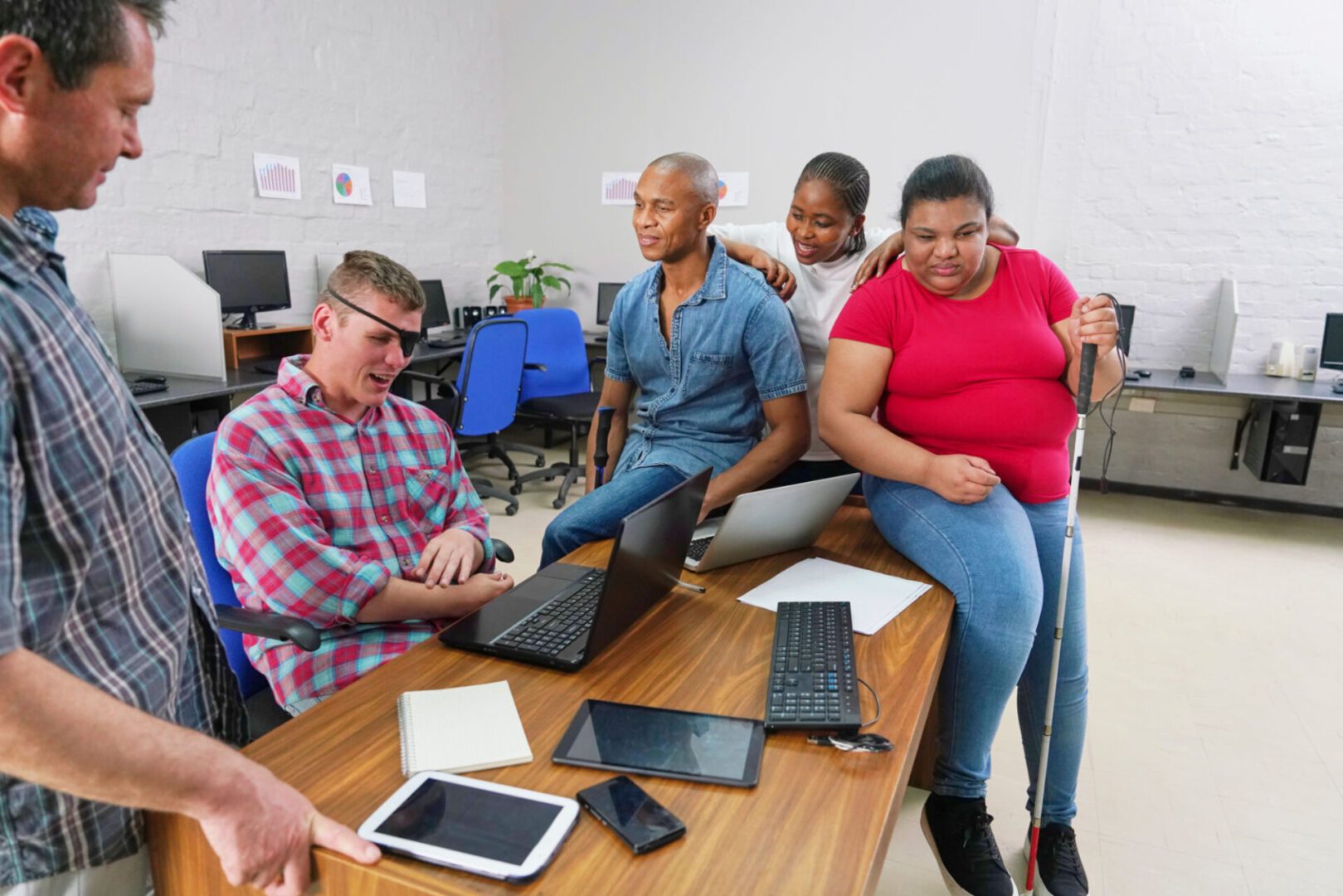 Diverse group collaborating around table with devices.