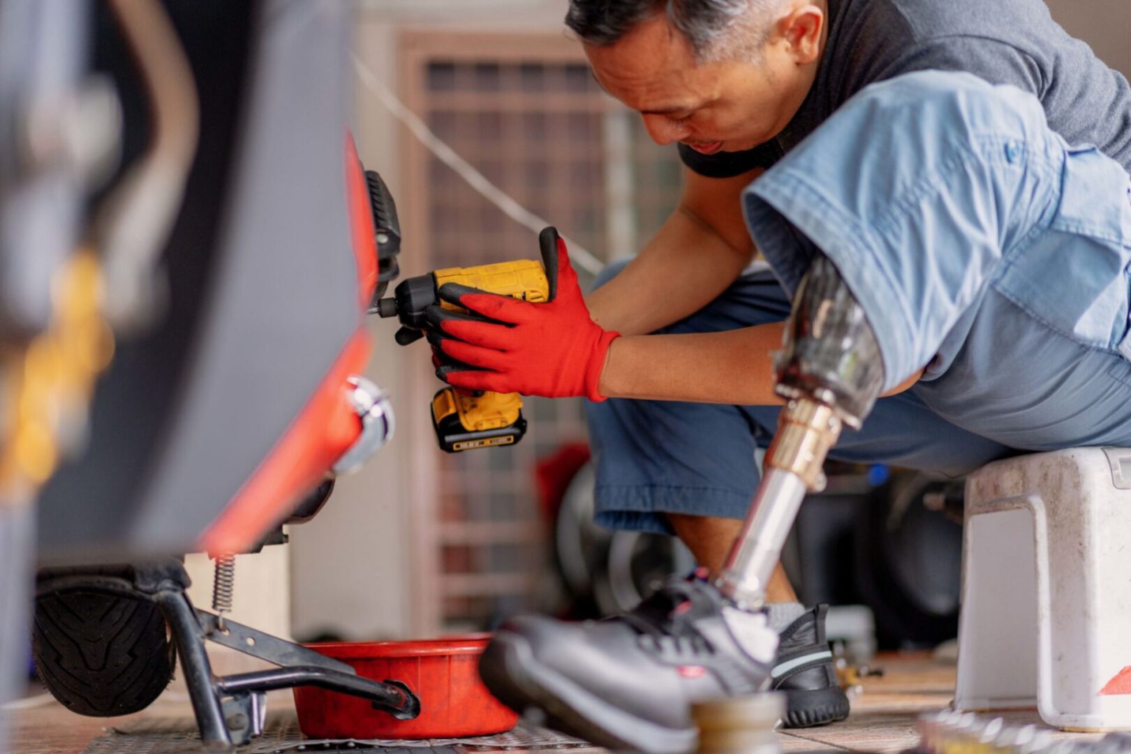Man with prosthetic leg using power drill.